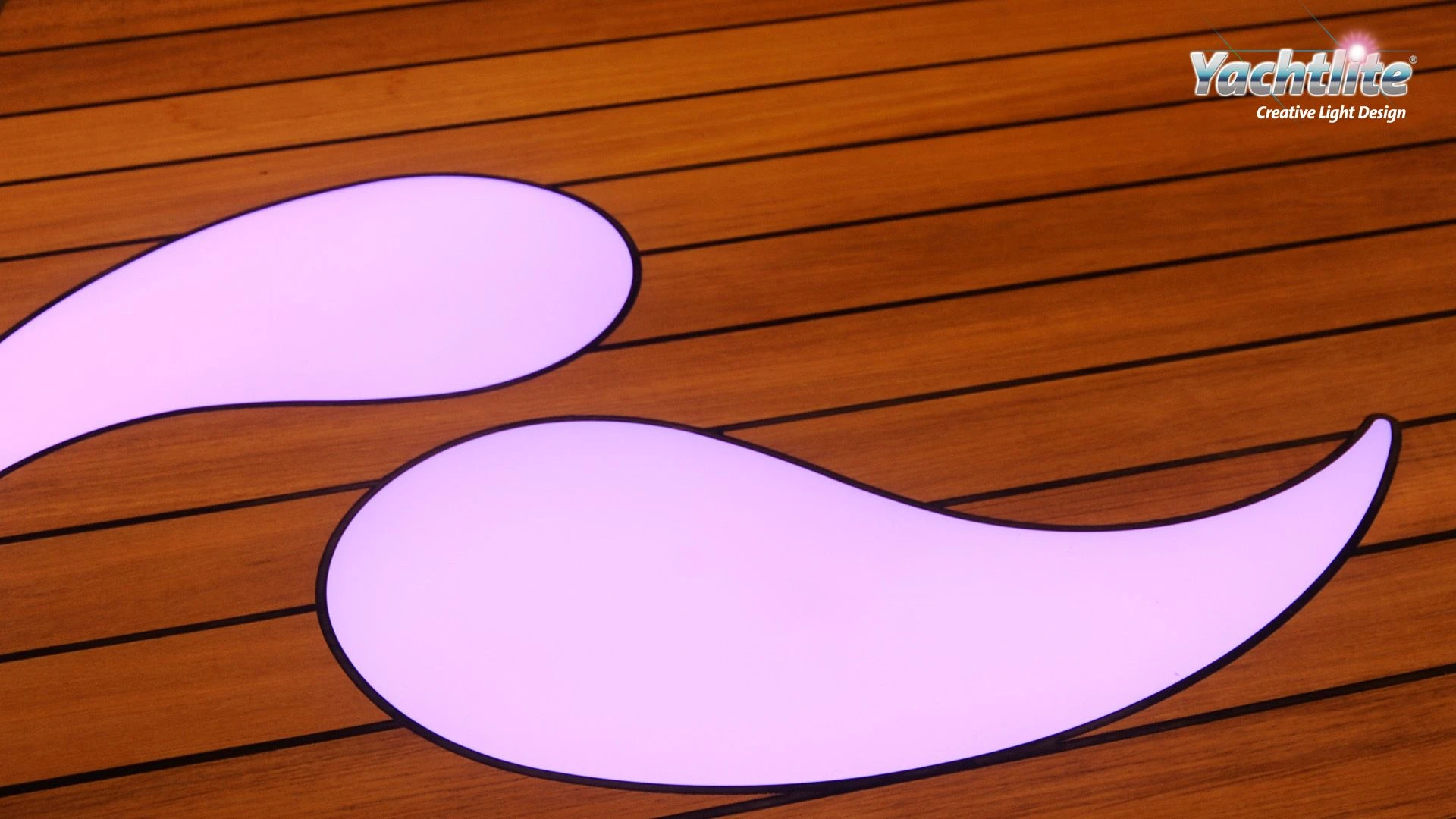 Close-up of Yachtlite FloorLite decorative illuminated inlays integrated into a teak yacht deck.