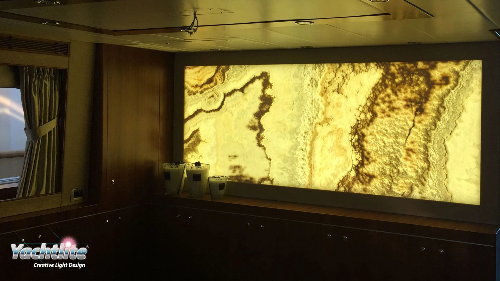 Luxury yacht interior featuring a large backlit onyx wall illuminated with Yachtlite RoomLite lighting.