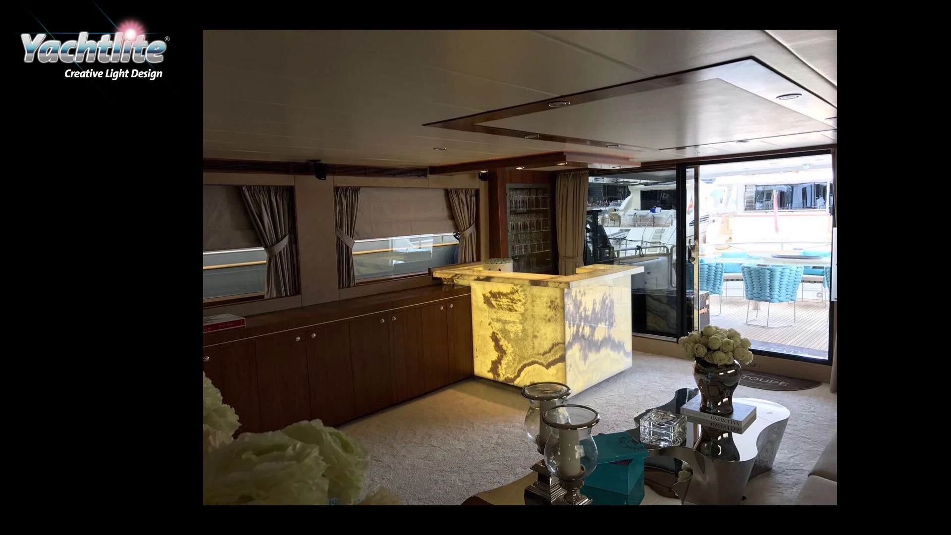 Luxury yacht salon featuring a glowing onyx-style bar illuminated with Yachtlite RoomLite lighting.