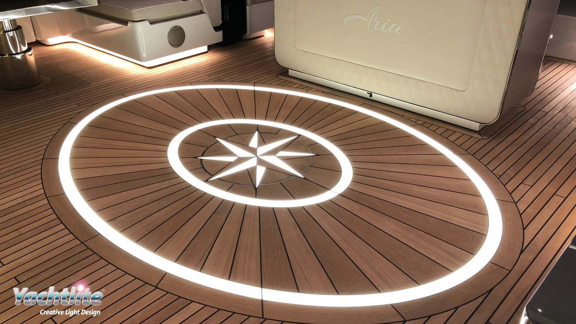 Luxury yacht deck featuring Yachtlite FloorLite illuminated flooring integrated into a teak wood compass rose design.