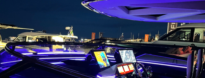 High-performance luxury yacht helm station illuminated with Yachtlite ambient LED lighting in vivid purple and blue tones.