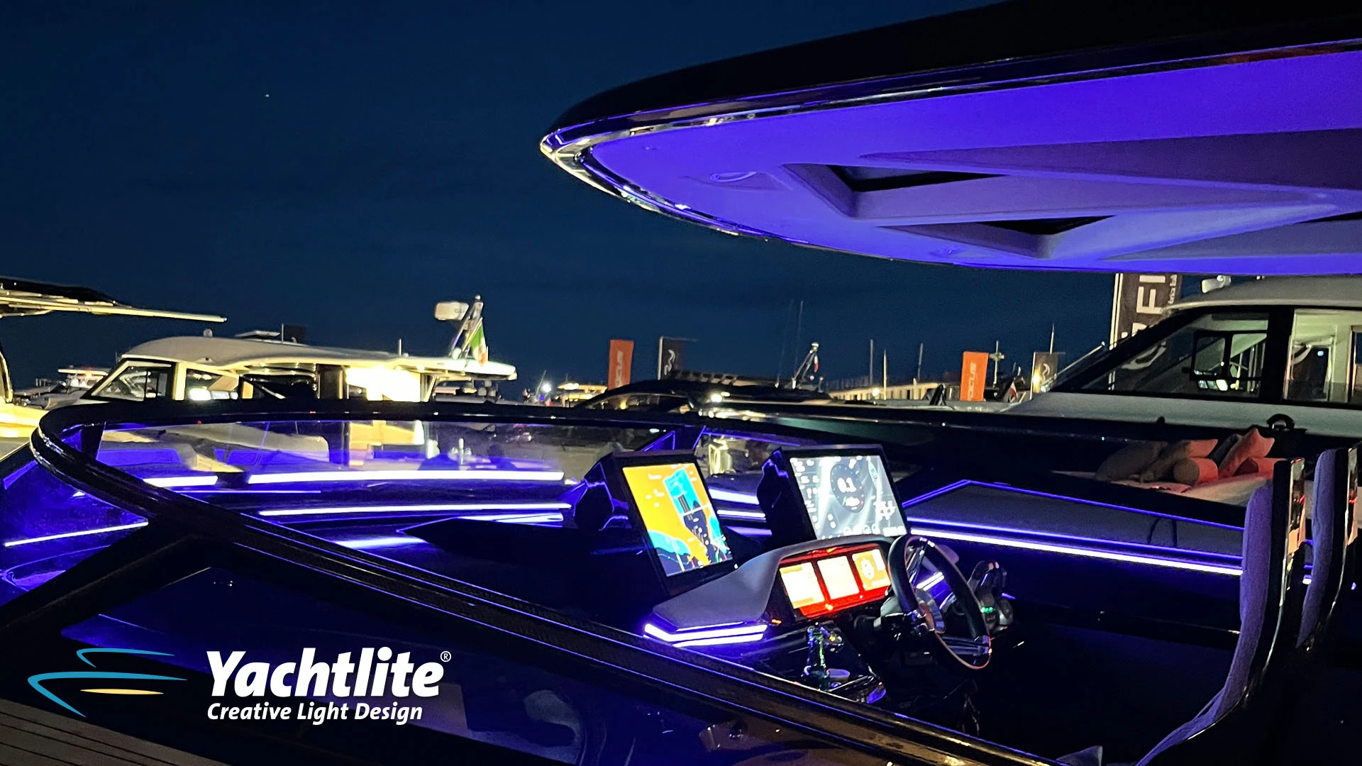 High-performance luxury yacht helm station illuminated with Yachtlite ambient LED lighting in vivid purple and blue tones.